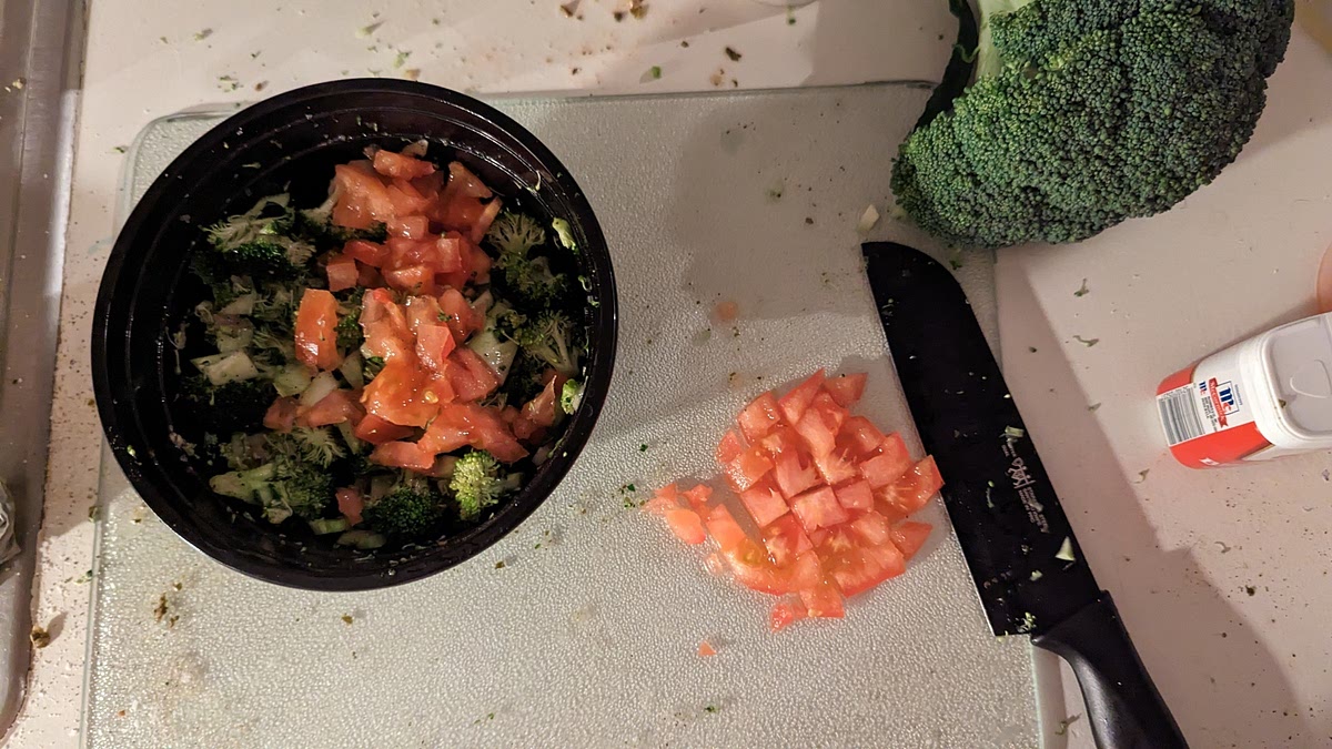 Toss broccoli, oil and the remaining 1/4 teaspoon each salt and pepper in a large bowl. If there are any tomato slices left, mix them in. Transfer the broccoli mixture to the empty side of the baking sheet.