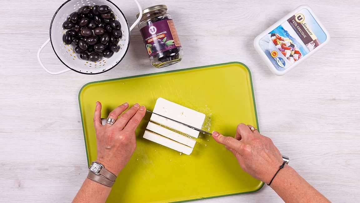 Coupez le bloc de feta en dés — par exemple en deux dans l’épaisseur, puis en quatre dans la largeur et en cinq dans la longueur. Égouttez les olives, rincez-les et épongez-les.
