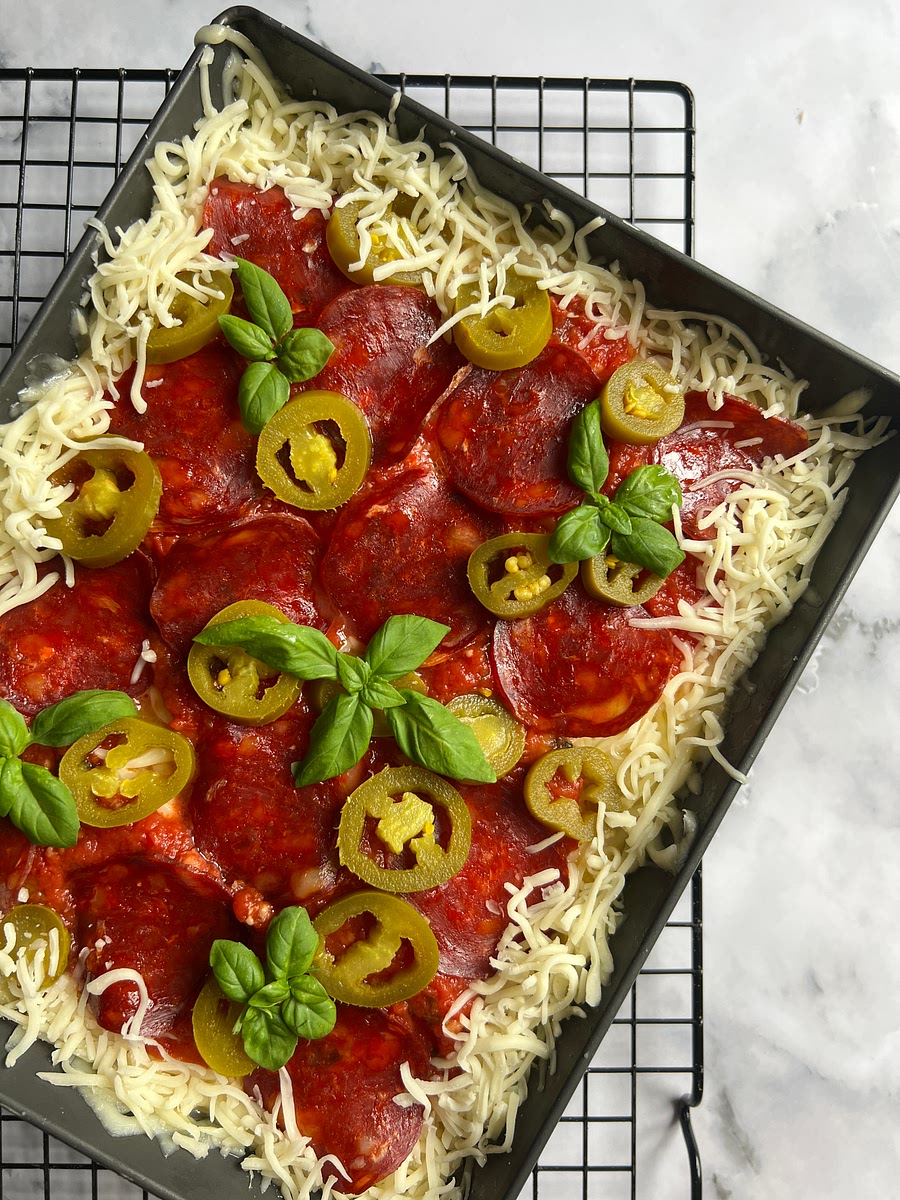 Take the reserved 3/4 cup (90g) of cheese and sprinkle it neatly around the border of the pan. This is what is going to help ensure you get a crispy, cheesy crust...it sinks down into the sides of the pan as it bakes.
