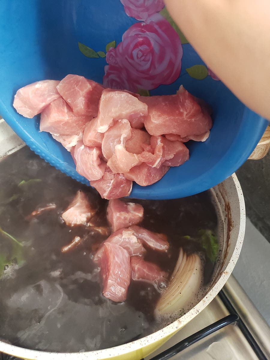 Una vez suaves los frijoles, es momento de añadir el puerco, la cebolla y el epazote.