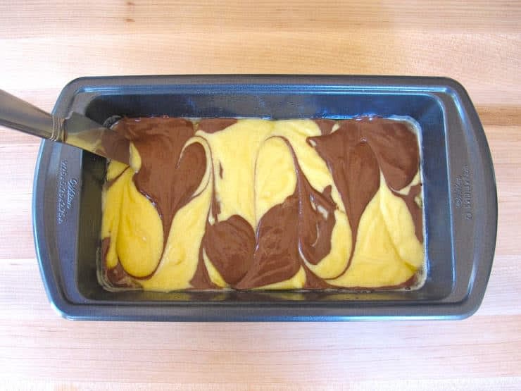 When both mixtures are complete, There is two ways you can do this. (Method.1) Start by putting a scoop of the vanilla mixture into the loaf pan so that it covers the bottom, then add a scoop of the coco mixture on top of that and use a butter knife to swirl it around, then continue doing so until the pan is filled. (Method.2) Put a spoonfull of the vanilla mixture into the pan, then add a spoonfull of the coco mixture, and then another spoon of the vanilla mixture, and so on.