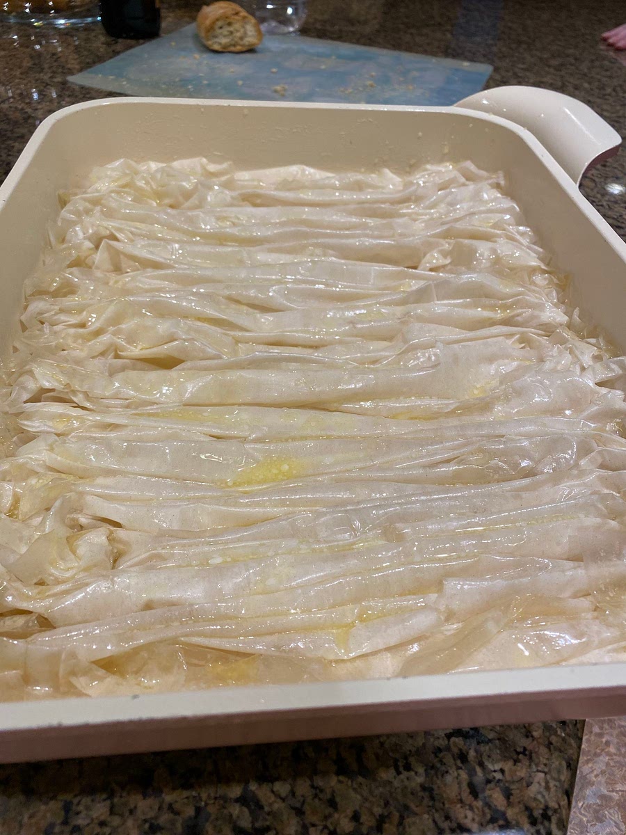 Once the pan is full of phyllo sheets, add some butter all over surface and edges