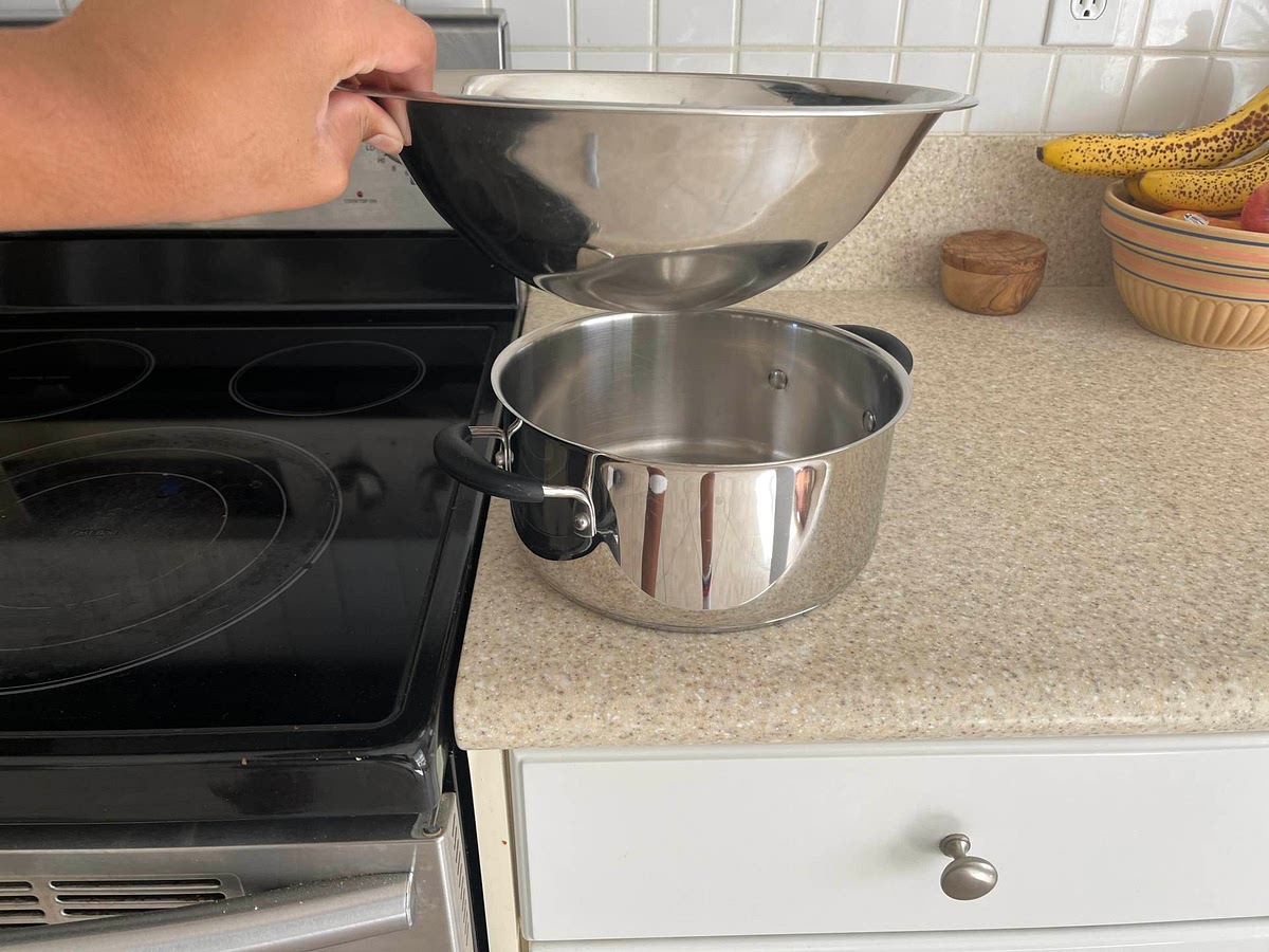 Full pot with water place on medium heat and place bowl over it The bottom of the bowl would be able to touch the water that is in the pot like seen in the photo