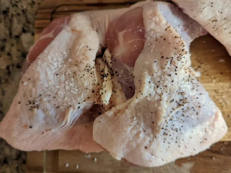 Add chicken to a mixing bowl and coat with salt and pepper.