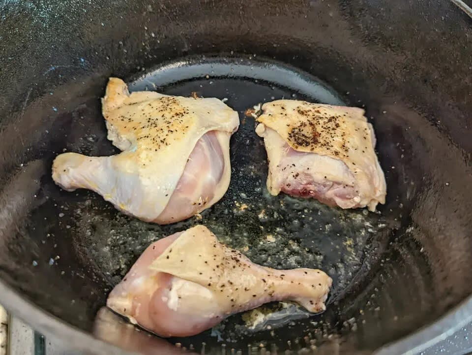 Warm the oil in a Dutch oven over medium heat. Add the chicken skin side down and sear for 3 minutes. Flip and sear for another 3 minutes. Set the chicken aside.