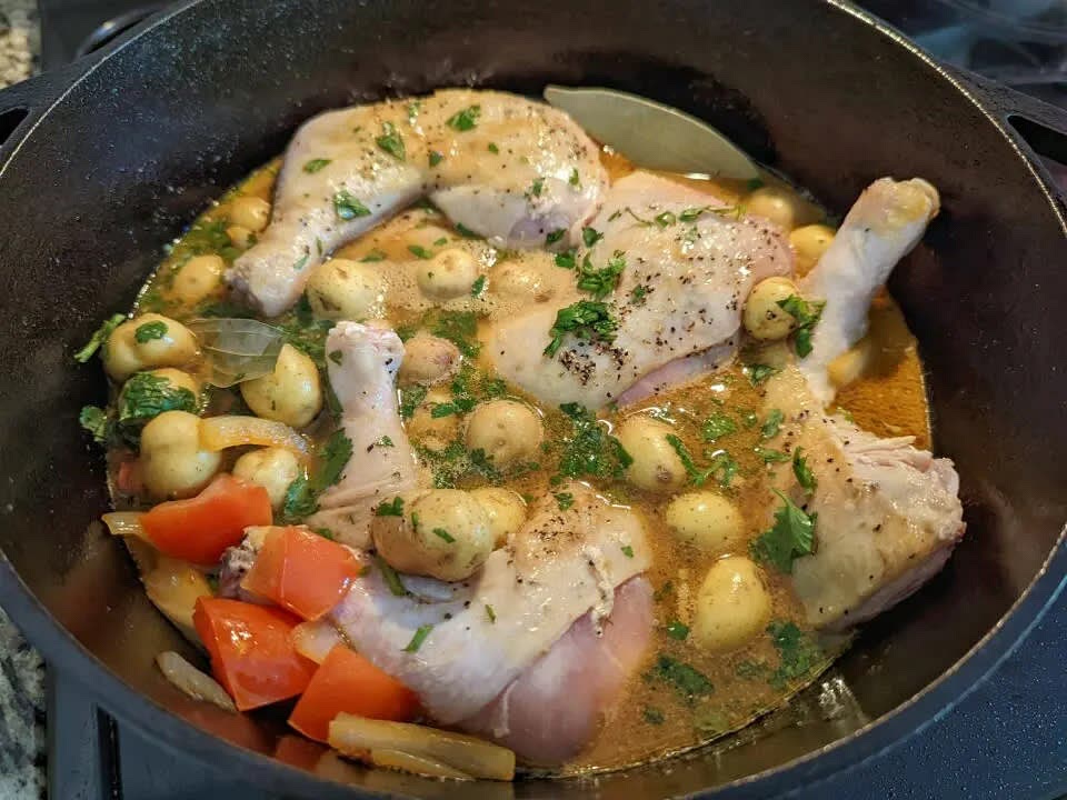 Deglaze with water, and nestle the chicken into the pot; add potatoes, bay leaves, and cilantro. Give the mixture a quick stir.