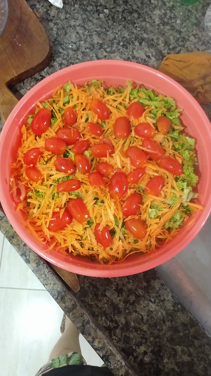 Em uma travessa faça uma camada com cenoura, uma com o alface, e uma com o tomate. Acrescente o molho por cima e cubra com a batata palha.