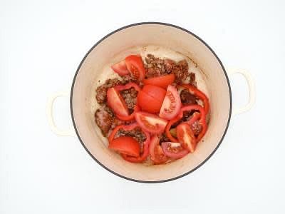 Meanwhile, deseed the sweet pointed pepper[s] and slice into rings. Add the pepper rings and tomato wedges to the dish, season with a pinch of salt and give everything a good stir. Put the dish in the oven, uncovered, for an initial 15 min