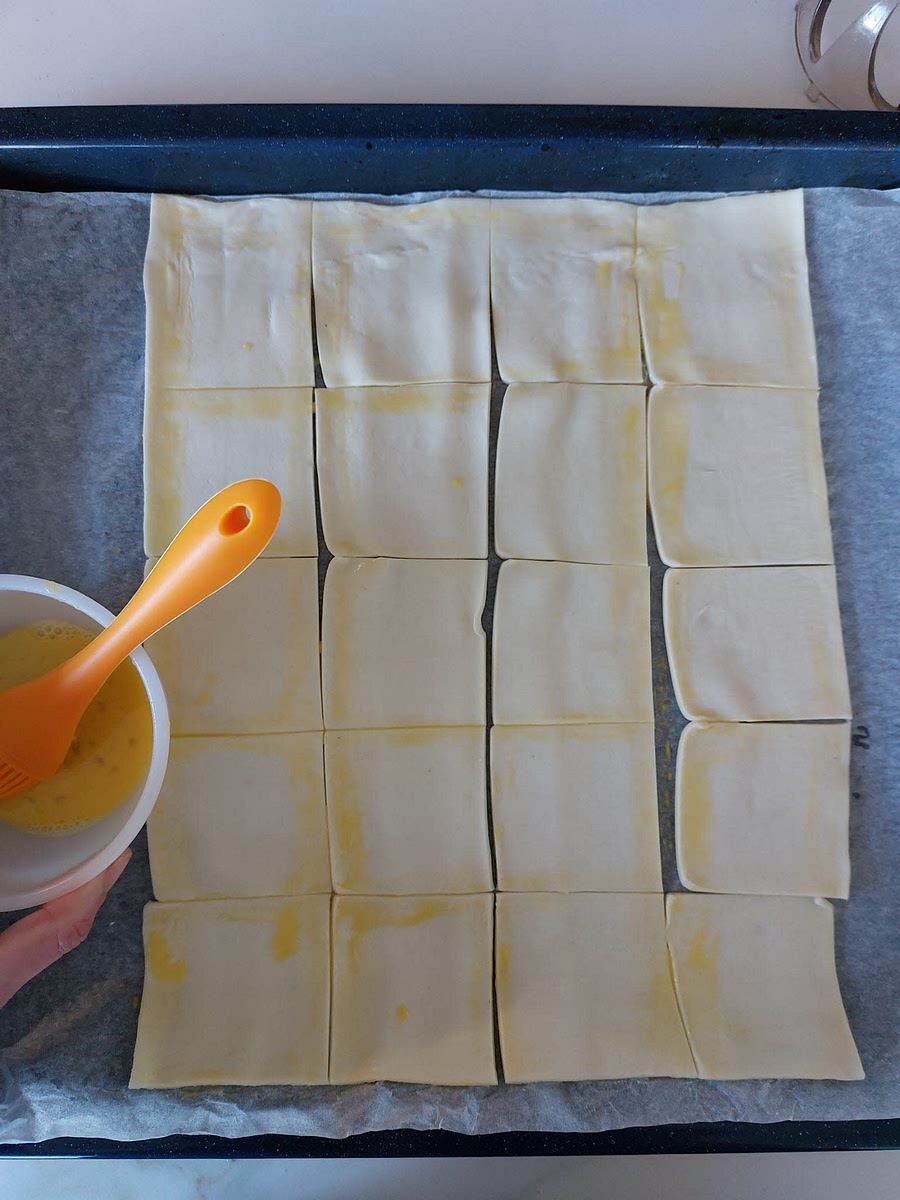 Con l'uovo tenuto da parte spennelli i bordi dei 20 pezzetti