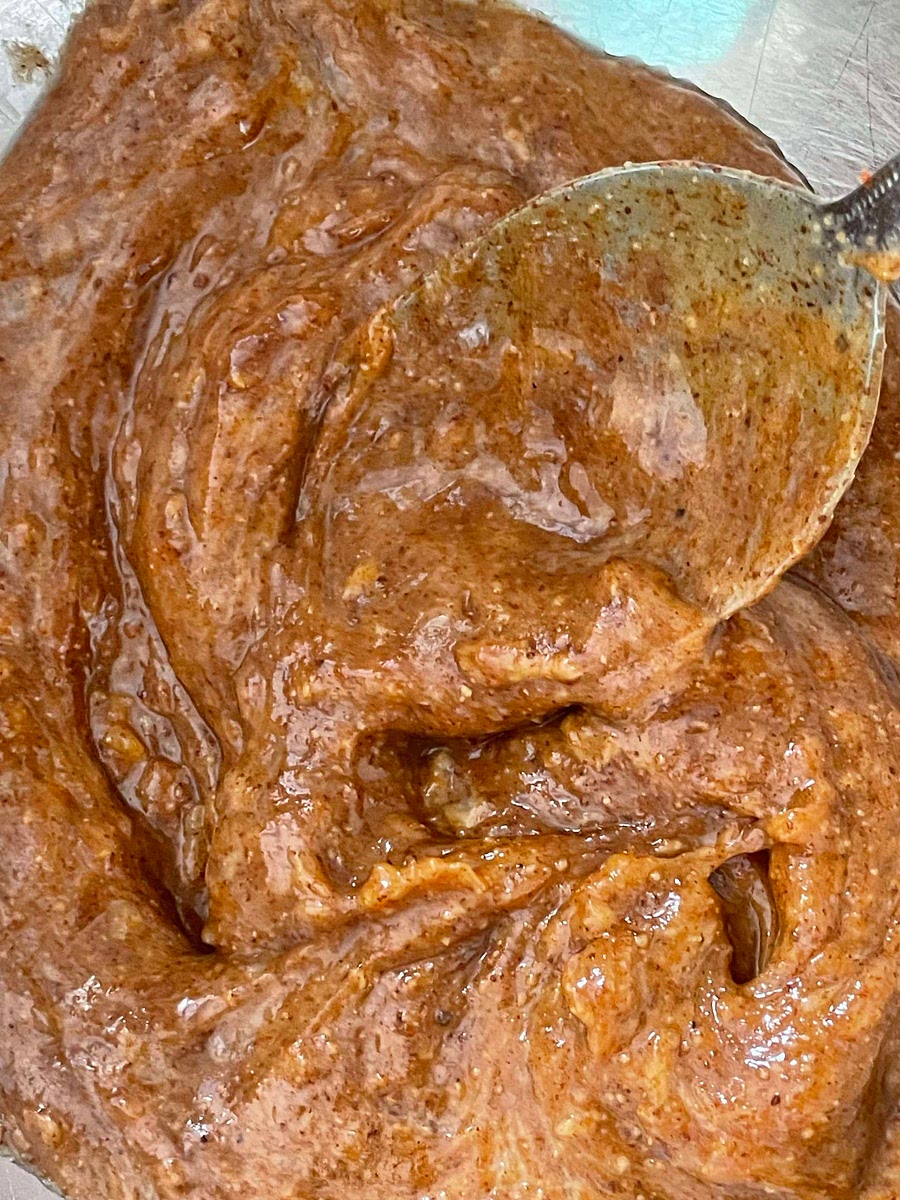 Scoop the flesh of the aubergine into a bowl. Squeeze out about 1 tablespoon of the cooked garlic and add to the bowl with the remaining 4 tablespoons of olive oil, the tahini/nut butter, lemon juice, spices and salt and pepper to taste.