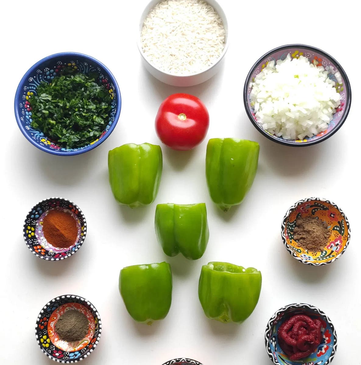 Prepare the vegetables Slice the tops of the bell peppers and cut out the stems from the tops. Chop the parsley, tomato, and onion finely.