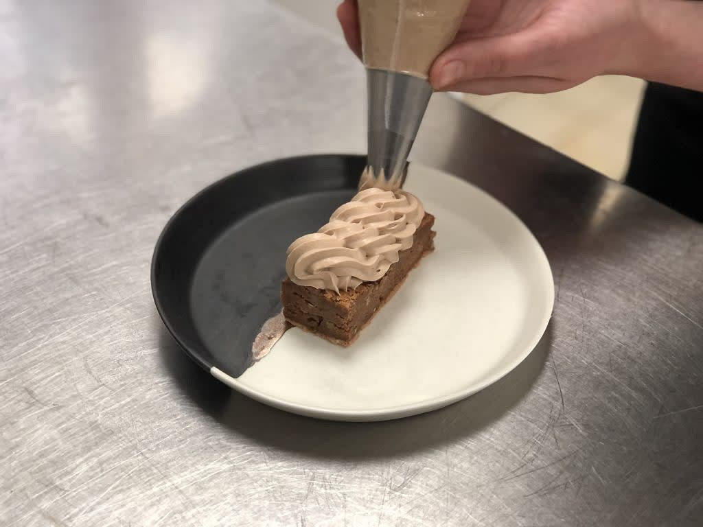 C’est le moment de se lâcher et de montrer toute sa créativité. Chloé nous conseille de se munir d’une poche à douille dans laquelle on incorporera la ganache pour réaliser de petits motifs sur le dessus du brownie. Une fois que cette étape est réalisée, déposer quelques cacahuètes sablées et le tour est joué ! Tiffany et Chloé conseillent un petit Pinot Noir pour aller avec ce dessert, à consommer légèrement frais.