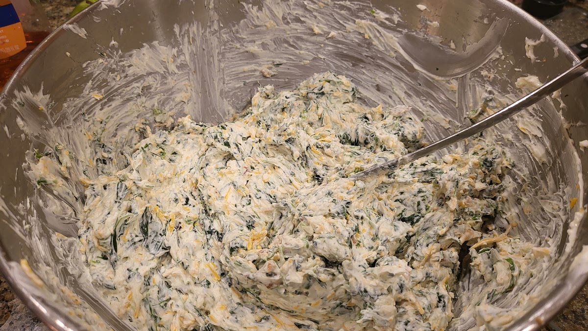 With a wooden spoon or spatula, stir in the spinach, cheese, bacon, onion, garlic, and seasonings.