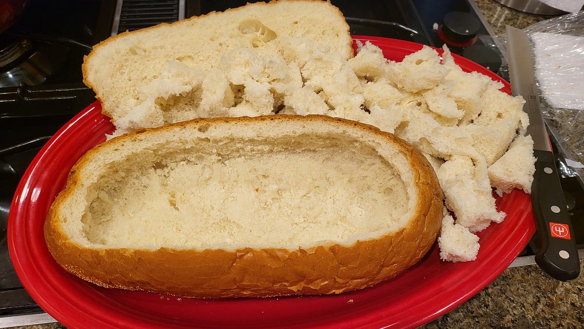 Hollow out the bottom of the bread, leaving a 1/2 inch shell, and being careful not to poke holes in the bottom/sides. Cube the bread that was removed and set aside.