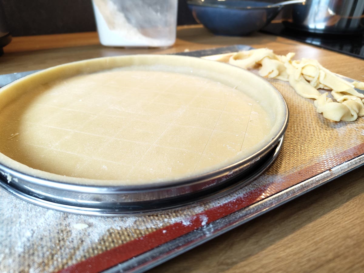 Préchauffer le four à 170c° et déposer la pâte dans un plat à tarte ou un cercle à tarte puis couper l'excédent. Réaliser un quadrillage à l'aide d'un couteau pour éviter que la pâte gonfle.