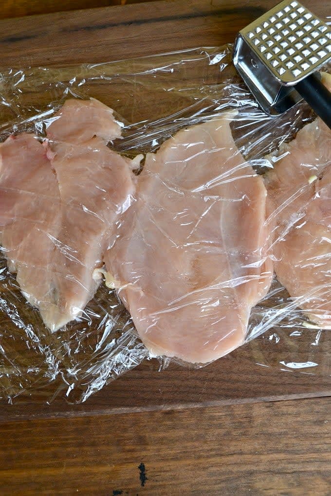 Dispón los filetes de pollo sobre la superficie de trabajo y sazónalos con sal y pimienta.