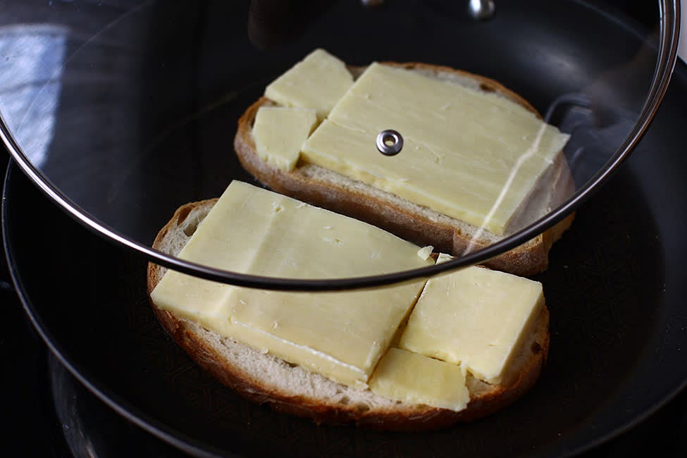 Place the bread slices (which, I repeat, are greased on both sides) in the pan, cheese side up, and cover with the lid. The fire must be small. Fry the bread until it browns on the side that comes in contact with the pan and the cheese melts (about 7-8 minutes).