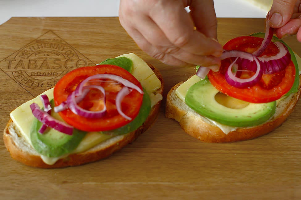 Place the tomato and onion slices on top of the avocado, sprinkled with salt and pepper to taste.