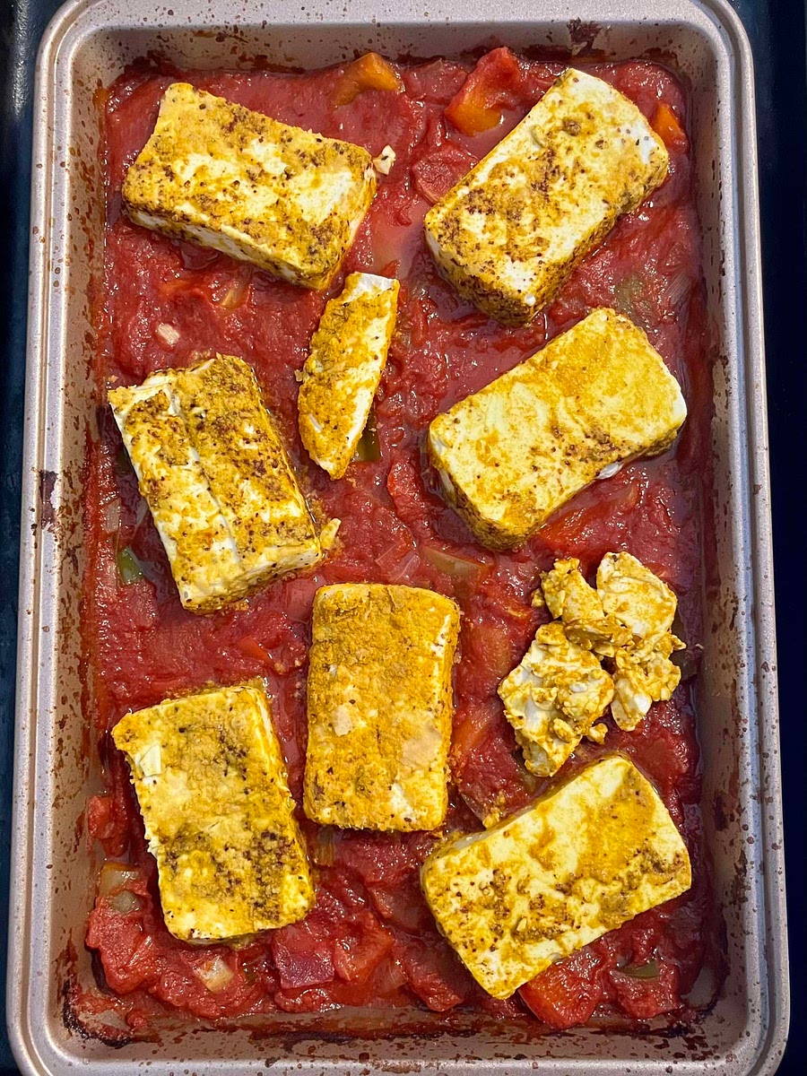 Place the sliced silken tofu on top of the tomato mixture and press the pieces in a little bit. Transfer the baking dish back into the oven and let it bake for another 10 - 15 minutes.