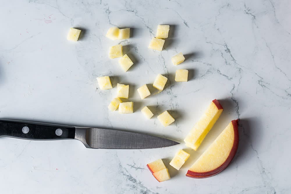 Peel, core and slice the apples into even cubes. Spread them out in the oven-proof dish.