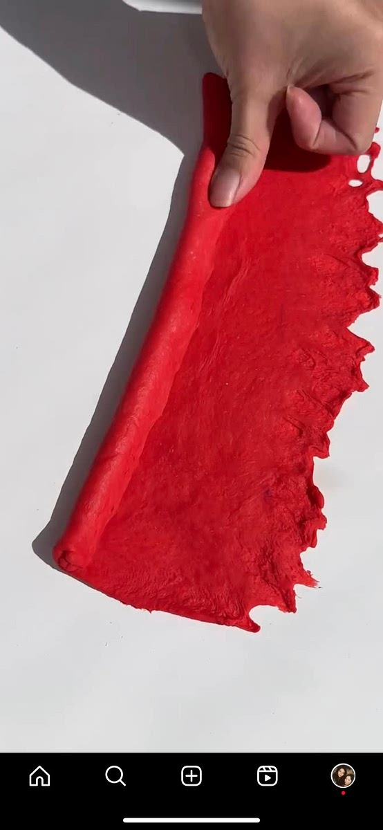 Roll out one red ball into a rectangle, and then roll the rectangle into a sausage shape and pinch to close. Push one side of the dough wide with a rolling pin, and wrap it around the other side, and pinch to close.