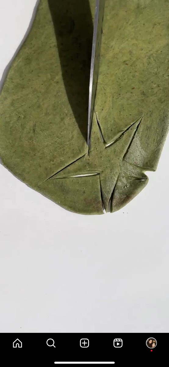 Roll out the green dough and use a knife to cut tomato top shapes, like irregular stars. Use a bit of water to stick the tops to the red bagels.