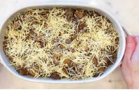 Transfer the mixture to the prepared baking dish. Sprinkle it with the shredded cheese.