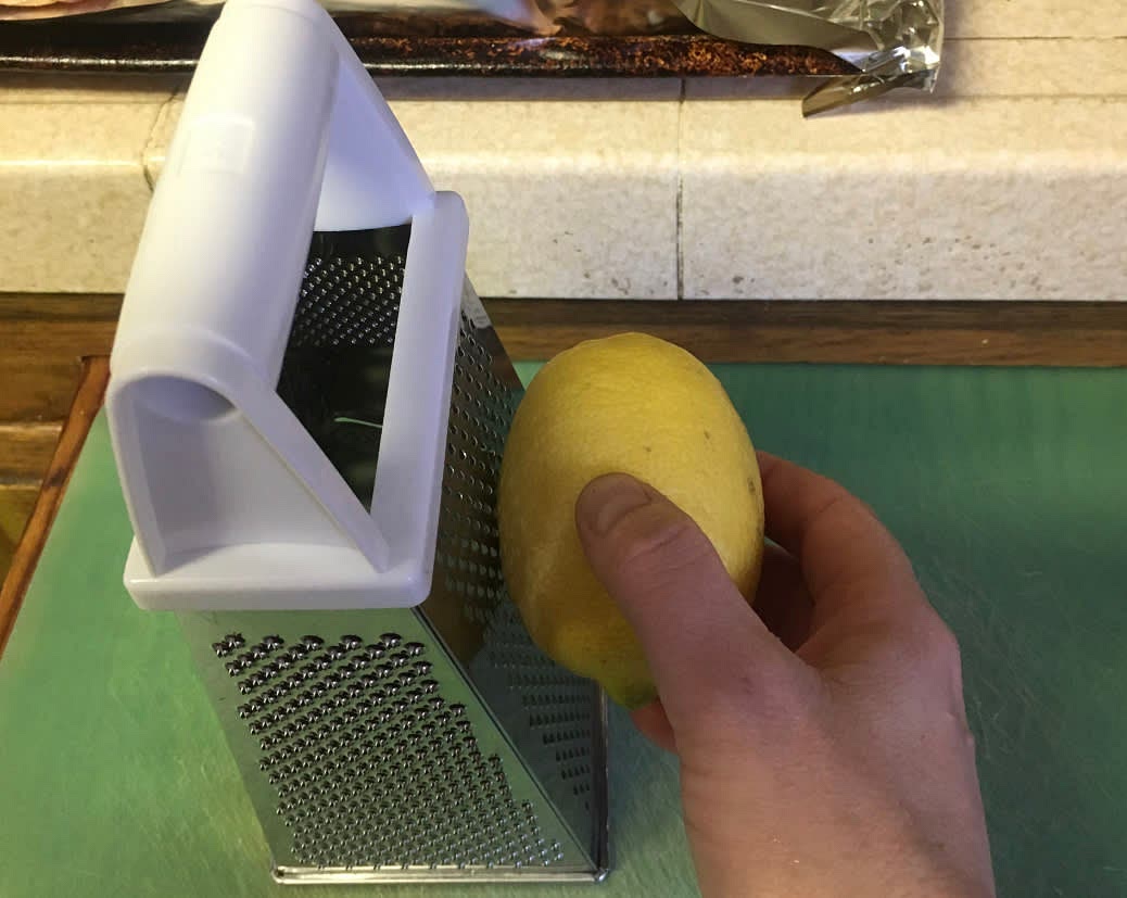 Wash and dry the lemons and zest it on the small holed side of a cheese grater on top of a cutting board. Only zest the yellow part of the skin, not the white. Pull out all the zest from inside the middle of the cheese grater.