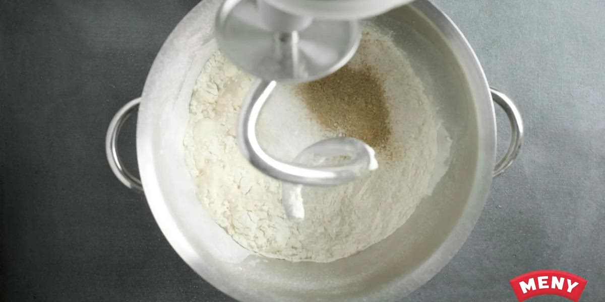 Füg Zucker, Mehl, Salz und Kardamom hinzu. Diese kannst du vorher schon zusammenrühren, bevor du es zum Rest gibst.
Knete den Teig 10 Minuten lang (in der Küchenmaschine auf Medium Geschwindigkeit). Füge ggf. mehr Mehl hinzu, bis der Teig sich von der Schüssel löst.