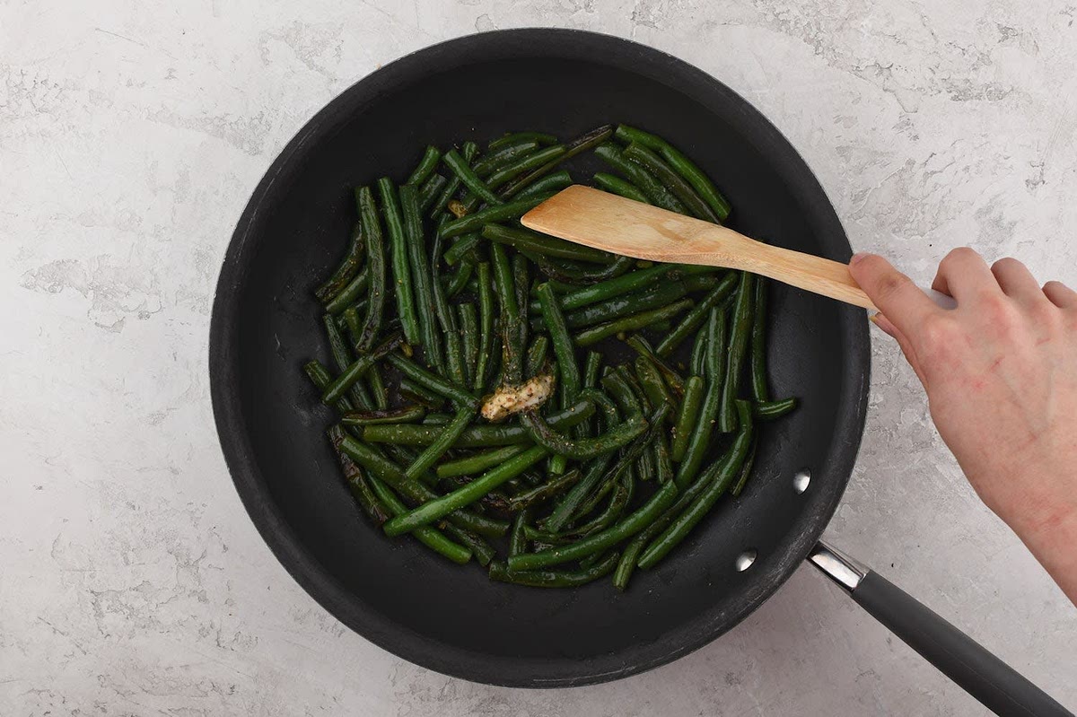 Trim green beans, if necessary. Place a large non-stick pan over medium-high heat and add 1 tsp. olive oil. Add green beans to hot pan and cook, 1 minute. Add 1/4 cup water. Cover, and cook until tender, 6-8 minutes. Uncover and add a pinch of salt, garlic pepper, and 2/3 the butter (reserve remaining for sauce). Toss until coated. Remove from burner. While green beans cook, continue recipe.
