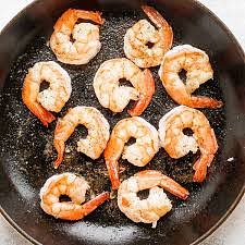 Pull the heads off the shrimp and place them in a wok or large skillet. Peel and clean the shrimp and set aside. *You can add the shrimp shells to the skillet as well, but the heads are the important part.