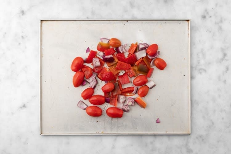 Add peppers, onions, tomatoes and 1 tbsp oil to an unlined baking sheet. Season with salt and pepper, then toss to combine. Roast in the middle of the oven, stirring halfway through, until tender, 14-15 min.