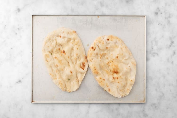 Combine 1 tbsp oil and garlic in another small bowl. Arrange flatbreads on another unlined baking sheet, then brush with garlic oil. Season with salt and pepper. Toast in the top of the oven until golden-brown, 2-4 min.