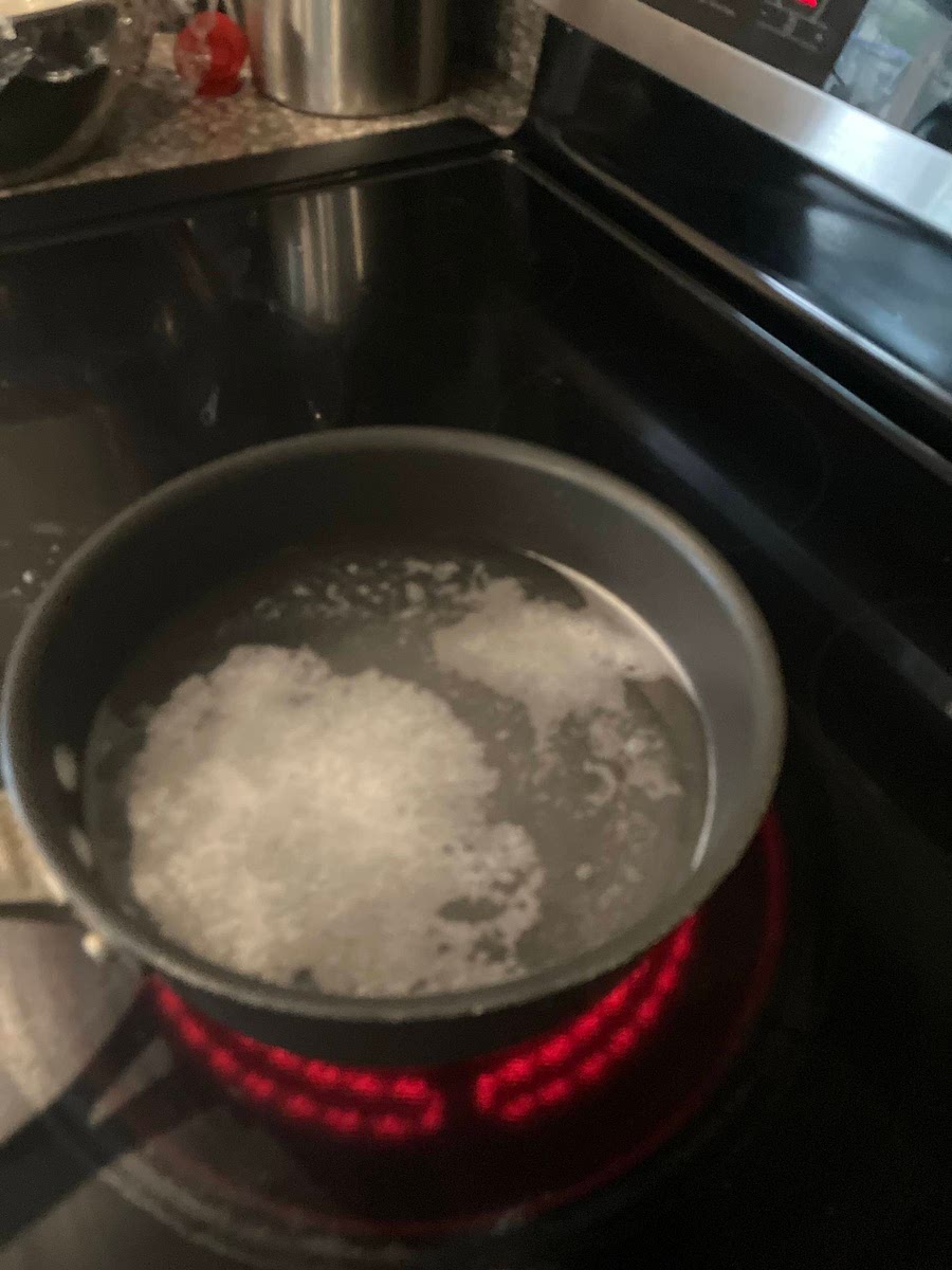 Prepare baking soda bath by setting water in a pot on the stove, and adding the baking soda.