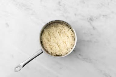 Before starting, add 1 1/4 cups water to a medium pot. Cover and bring to a boil over high heat. Wash and dry all produce. Once water is boiling, add rice, stock powder and 1 tbsp butter. Stir to combine. Reduce heat to low. Cover and cook until rice is tender and liquid is absorbed, 12-14 min. Remove the pot from heat. Set aside, still covered.