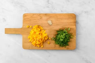 Meanwhile, core, then cut pepper into 1/2-inch pieces. Peel, then mince or grate garlic. Finely chop green onion.
