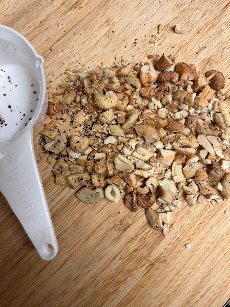 Chop the cashews roughly (I like to use salt and pepper cashews) and then finely dice or crush the two cloves of garlic. Add both to the beans