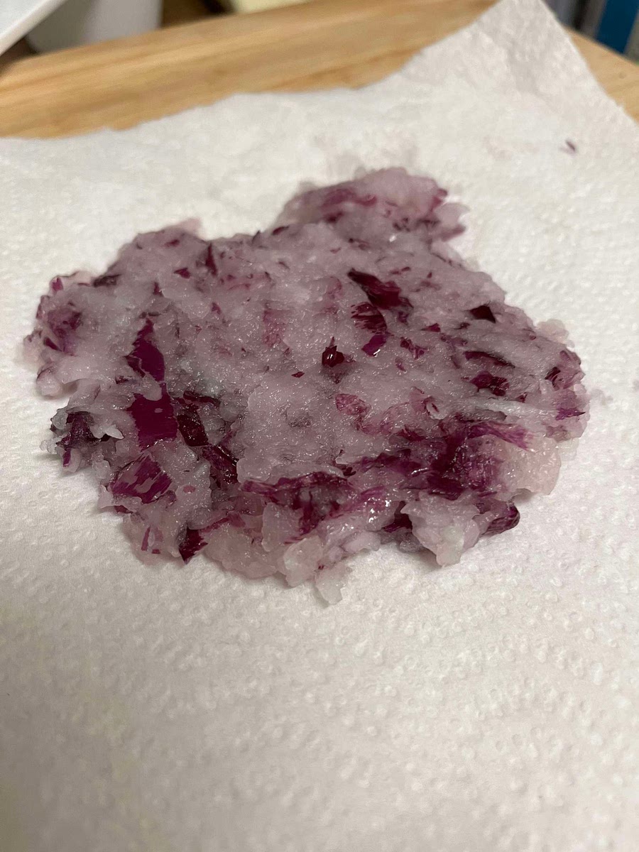 Peel and then grate the onion up to the root, and squeeze out as much liquid as you can. You may want to drain with a paper towel as well. Once most the moisture is gone, add this to the beans