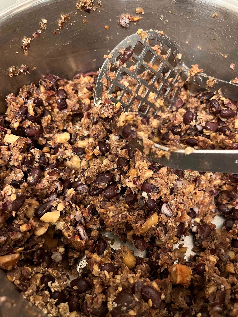 Mash the mixture so that it combines and begins to form together. You want it so that some of the beans are fairly mashed but that there are still bits of bean.