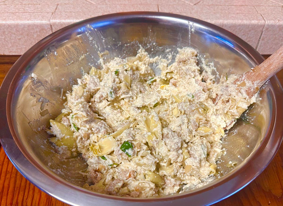 Bring out the large mixing bowl from the fridge and add the cooled ground turkey to the ricotta cheese mixture. Stir until it is completely mixed.