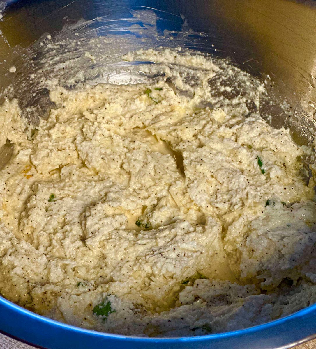 In a large mixing bowl, combine ricotta, parmesan-asiago-romano cheese, 2 eggs, basil leaves, 1/2 tsp salt, 1/2 tsp pepper. Mix well with a wooden spoon until combined. Place this bowl in the fridge to rest.