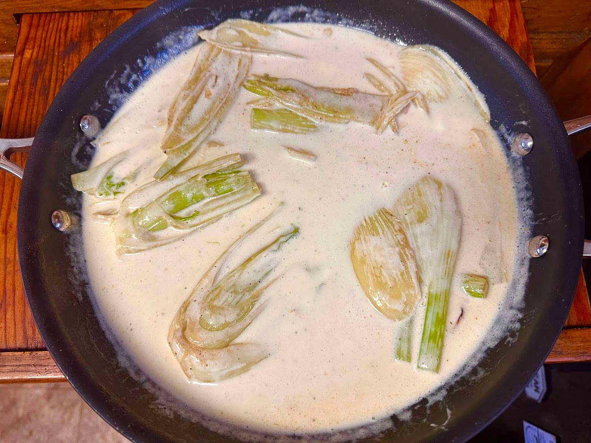 Melt the butter in a large skillet over medium heat. Add the fennel, salt and pepper to taste and fry for about 5 minutes. Stir in the half-and-half and creme fraiche until well blended. Transfer to a shallow baking dish. Sprinkle Parmesan cheese over the top.