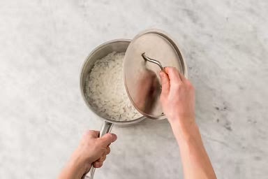 Add 1 1/4 cups water and half the garlic salt to a medium pot. Cover and bring to a boil over high heat. Once boiling, add rice, then reduce heat to low. Cover and cook until rice is tender and liquid is absorbed, 12-14 min. Remove the pot from heat. Set aside, still covered.