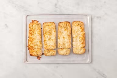 Meanwhile, halve buns. Arrange buns on an unlined baking sheet, cut-side up. Spread 2 tbsp softened butter on cut sides. Sprinkle cheese over top buns. Toast in the top of the oven until cheese is melted and bottom buns are golden, 4-5 min.