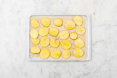 Cut potatoes into 1/4-inch rounds. Add potatoes and oil to a parchment-lined baking sheet. Season with BBQ Seasoning, salt and pepper, then toss to coat. Roast in the bottom of the oven, flipping halfway through, until tender and golden-brown, 18-20 min.