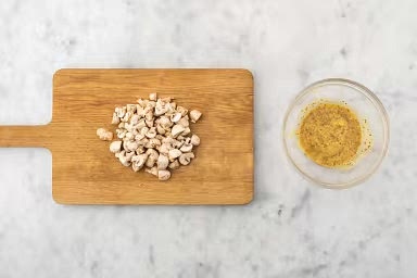 Meanwhile, on a clean cutting board, quarter mushrooms. Peel, then cut half the shallot into 1/4-inch pieces. Peel, then quarter eggs. Whisk together Dijon, whole grain mustard, vinegar and half the maple syrup in a large heat-proof bowl.