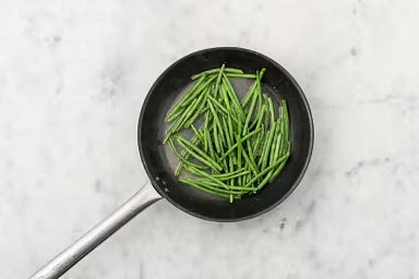 When pan is hot, add green beans and 1/4 cup water. Season with salt and pepper. Bring to a simmer. Once simmering, cook, stirring occasionally, until green beans are tender-crisp and water has evaporated, 4-5 min. Add butter and garlic puree. Cook, stirring often, until fragrant, 30 sec. Transfer green beans to a plate.