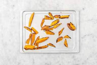 Before starting, preheat the oven to 425˚F. Wash and dry all produce. Cut sweet potatoes into 1/2-inch wedges. Add sweet potatoes and oil to an unlined baking sheet. Season with pepper and garlic salt, then toss to coat.