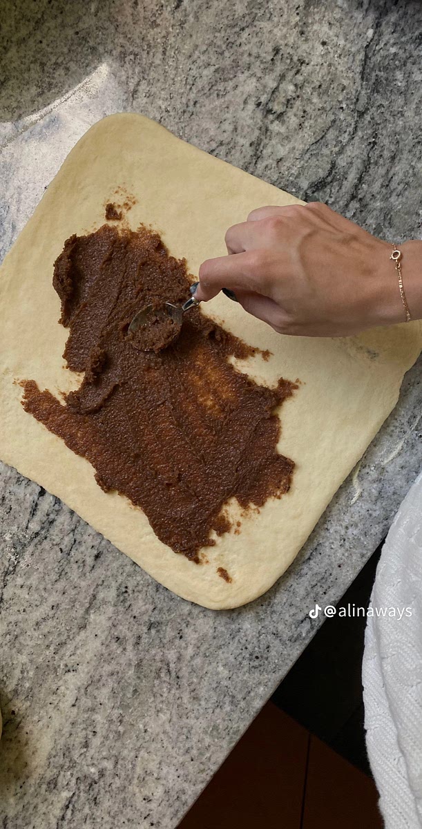 Once the dough has risen knead it until it's nice and smooth. Then roll it out into a long rectangle on a well floured surface. Spread the filling on top and form it into a tight roll.