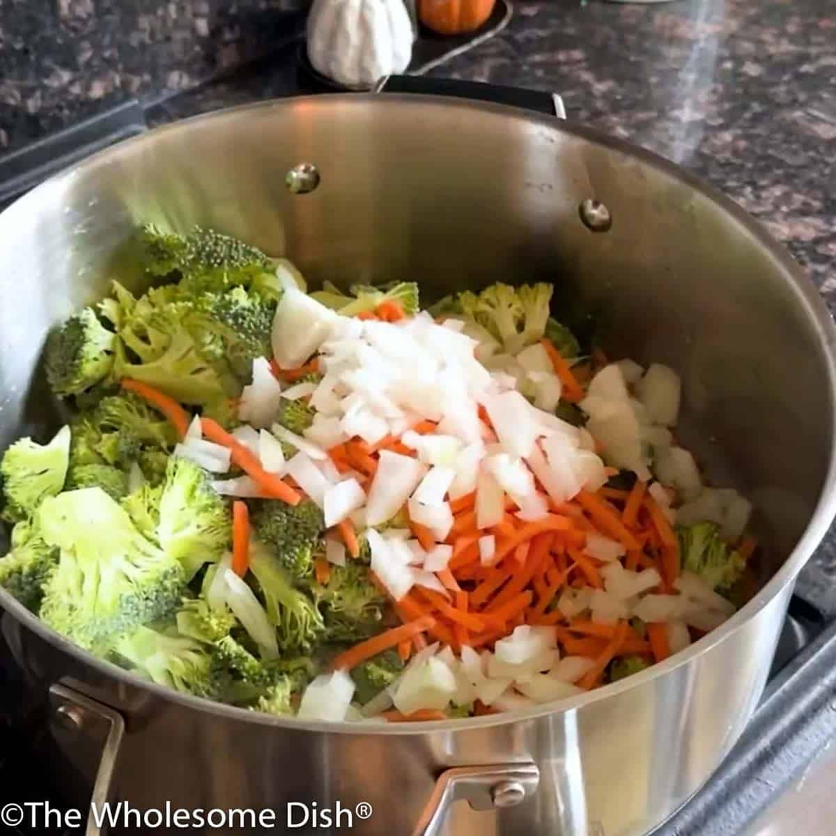 Add the oil and butter to a large soup pot and place it over medium-high heat. Once the butter is melted, add the broccoli, carrots, and onions. Cook, stirring occasionally, for 7-8 minutes, until the onion is translucent and the broccoli is soft.